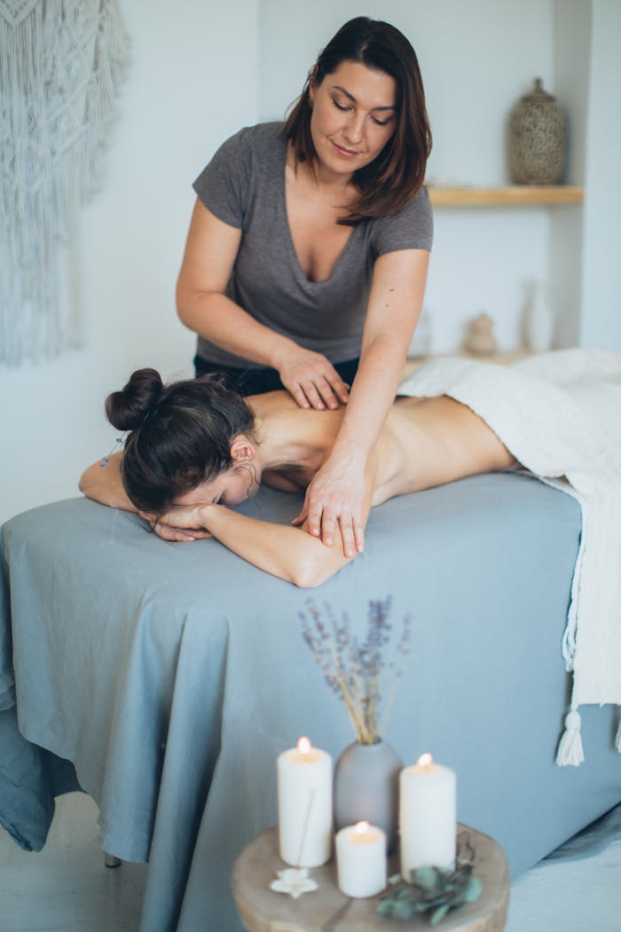 our-experience A serene spa setting with a therapist giving a back massage to a female client for relaxation.